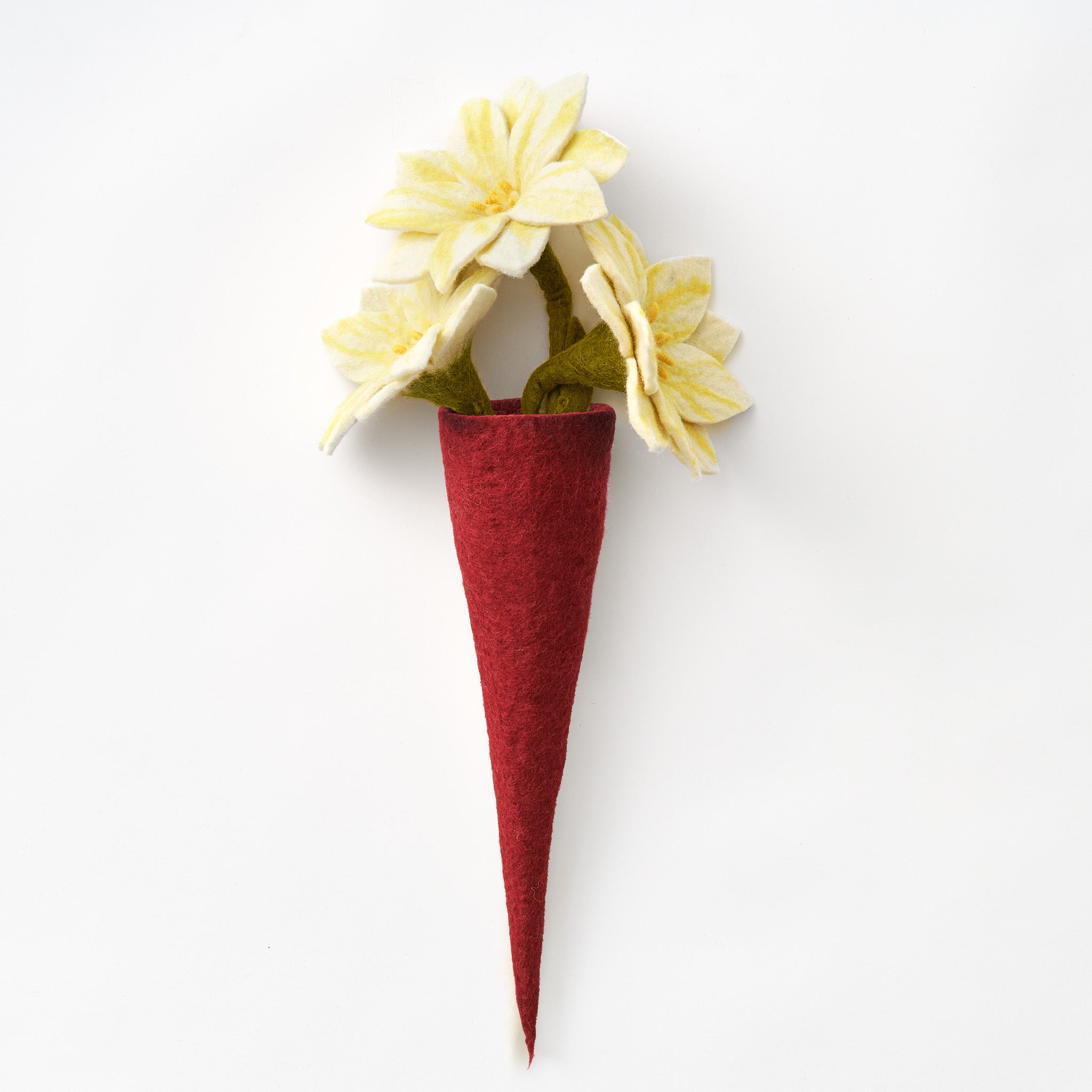 A handmade, fair trade felt vase in deep red, holding pale yellow felt flowers with green stems, photographed against a plain white background | Global Goods Partners