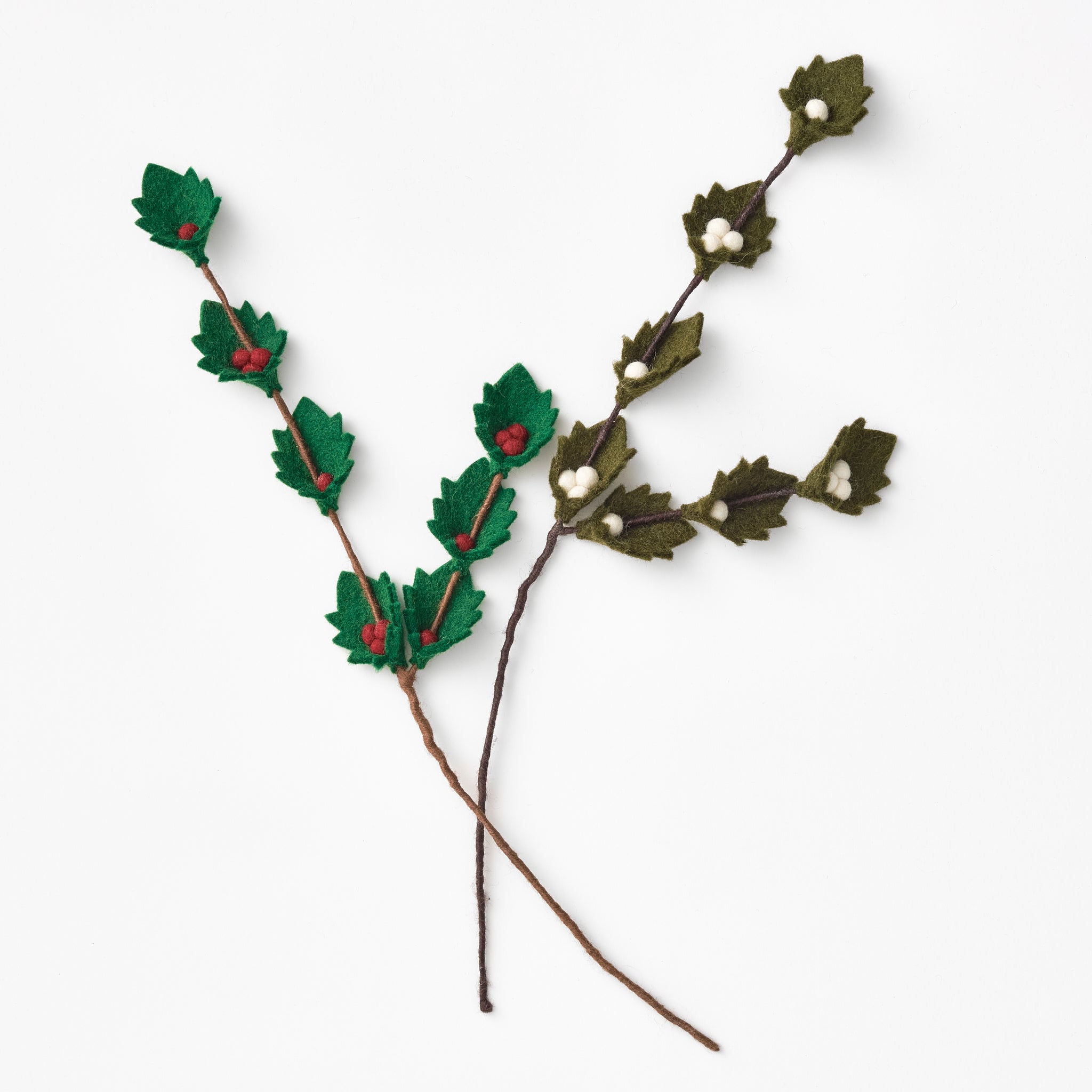 Decorative felted, wire-wrapped holly branch with green leaves and red berries on a white background. Handmade by women artisans | Global Goods Partners