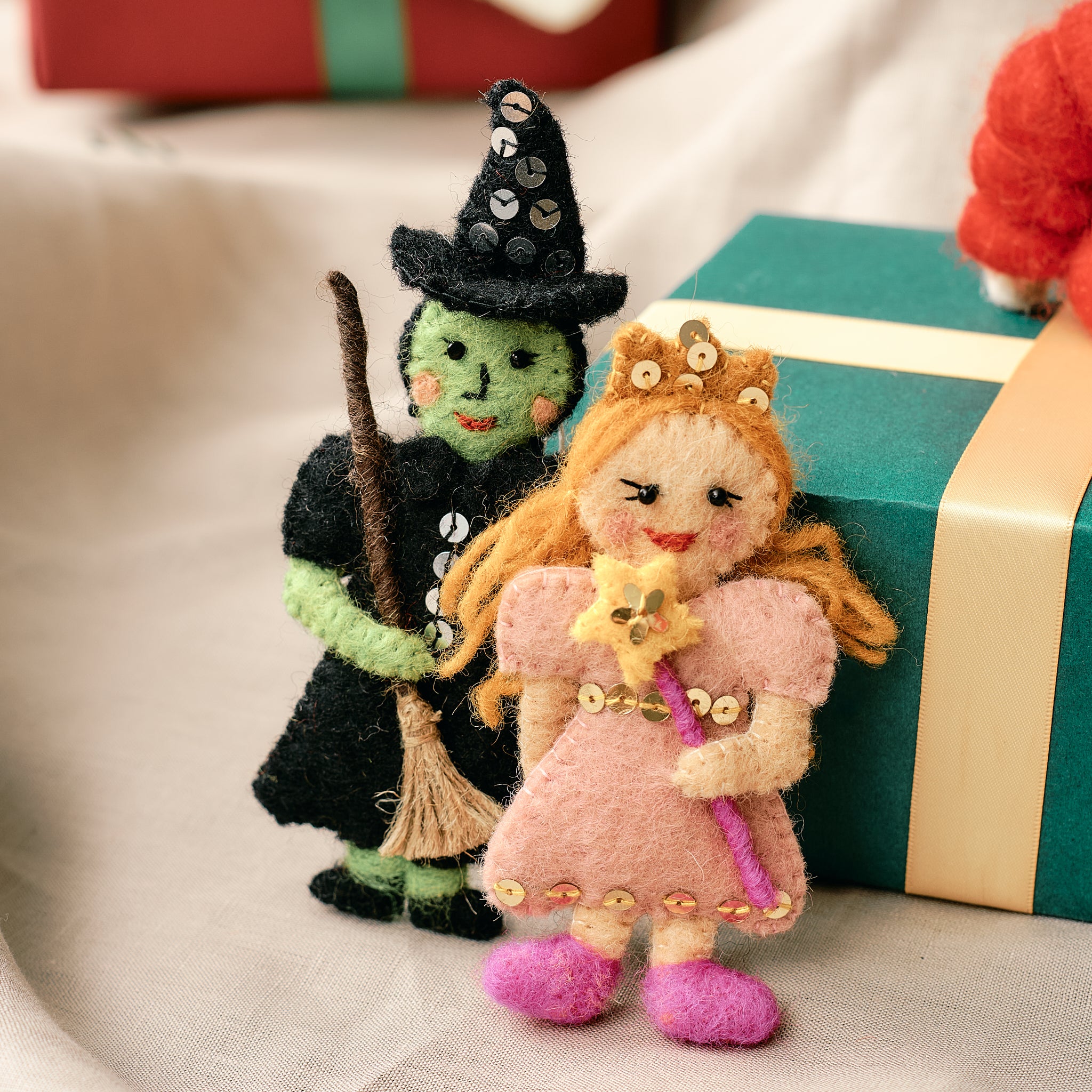 Handmade, fair trade wizard of oz ornaments in front of wrapped presents | Global Goods Partners