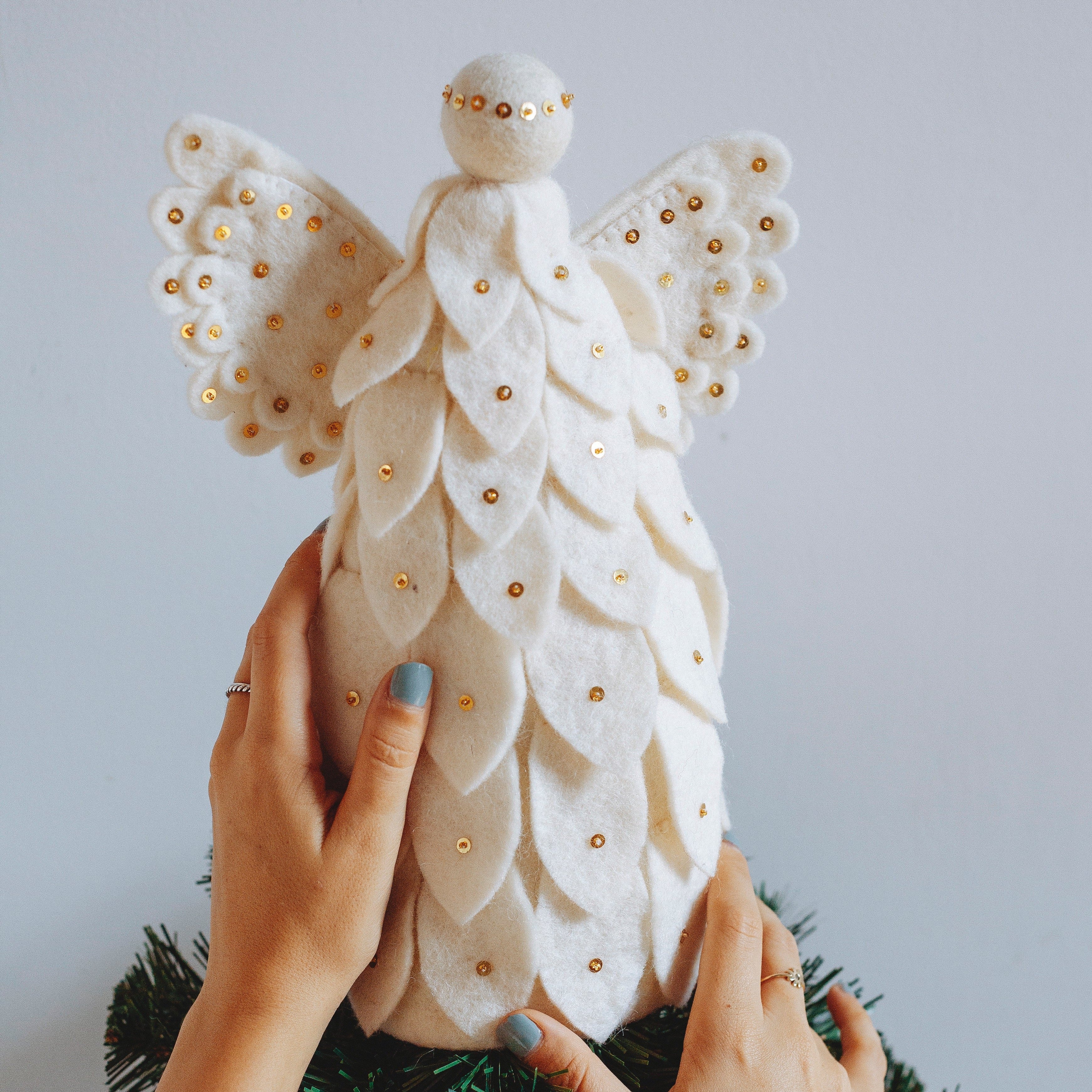 Felt angel being placed on top of a tree