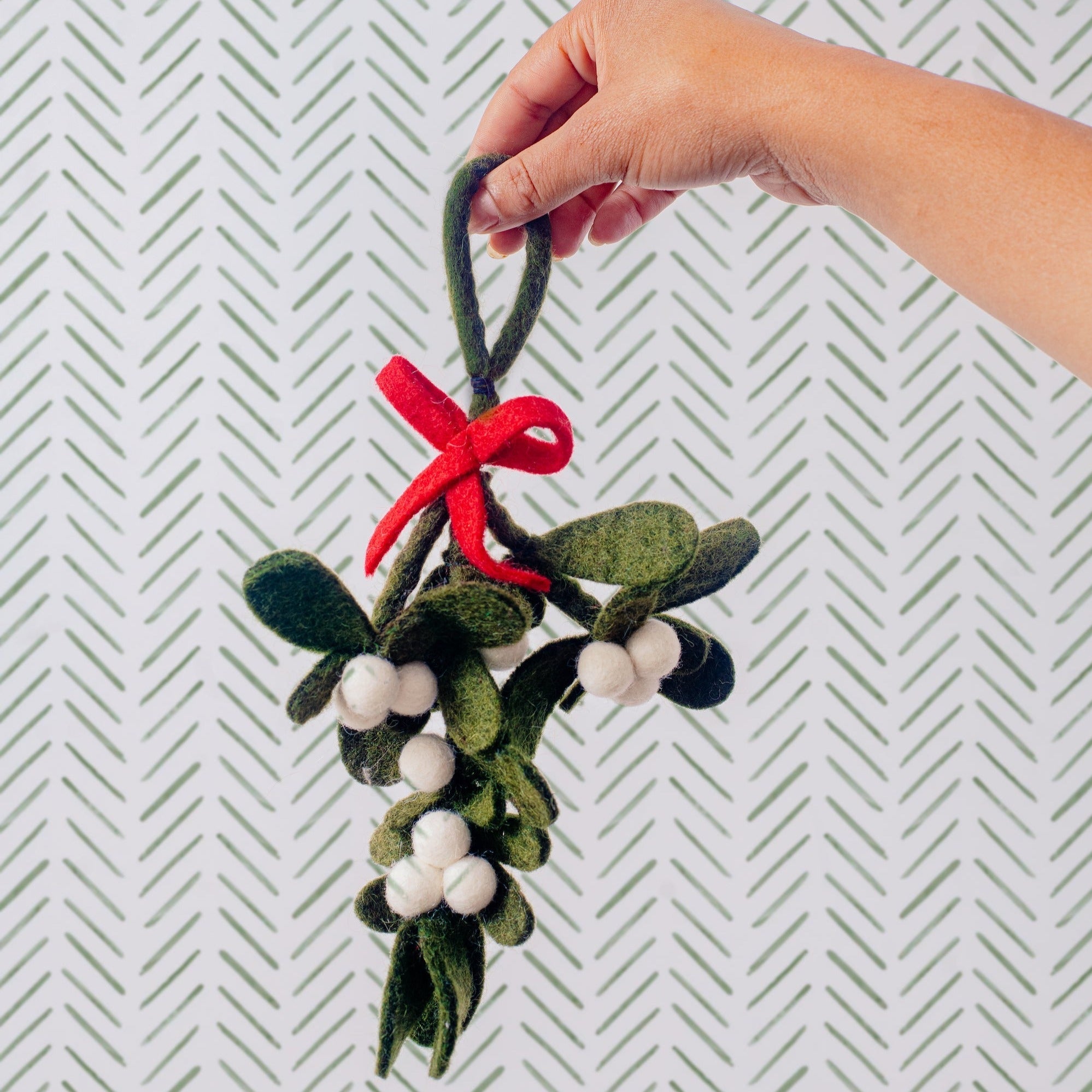 Hand holding Felt MistleToe Ornament with Loop and Red Ribbon - Global Goods Partners Fair Trade