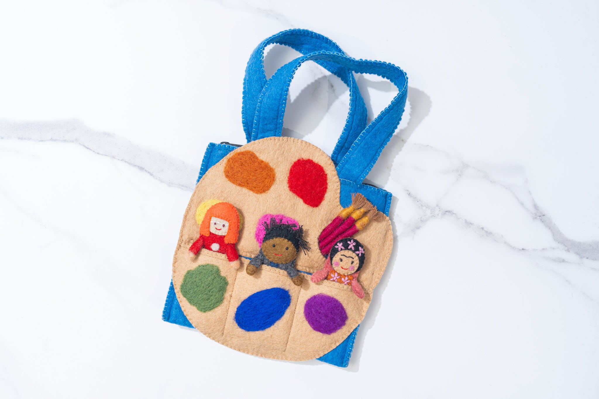 Felt puppet bag with felted art palette with colorful paint swatches and small dolls on a white background with three artist finger puppets, making a perfect faire trade handmade toy | Global Goods Partners