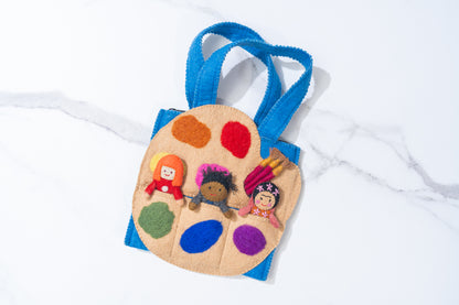 Felt puppet bag with felted art palette with colorful paint swatches and small dolls on a white background with three artist finger puppets, making a perfect faire trade handmade toy | Global Goods Partners
