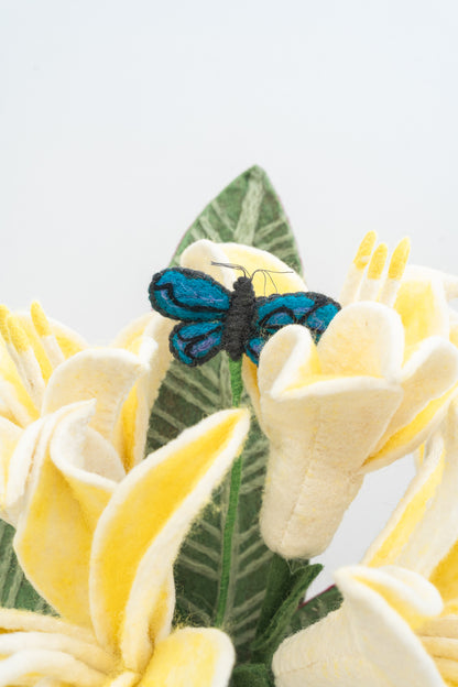 Felt butterfly and yellow flowers with green leaves on a white background, handmade and fair trade | Global Goods Partners