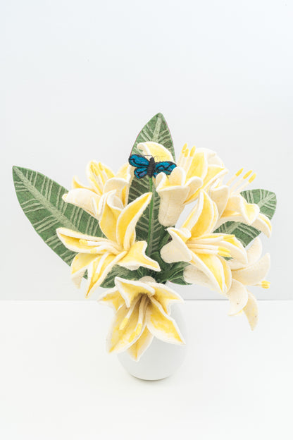 Decorative arrangement of felt yellow flowers and green leaves with a blue butterfly on a white background, all handmade by women artisans from Nepal | Global Goods Partners