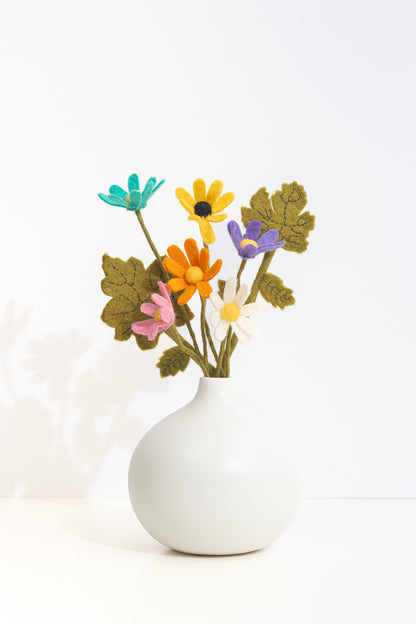 White vase with colorful handmade felt flowers on a white background, made by women artisans in Nepal | Global Goods Partners