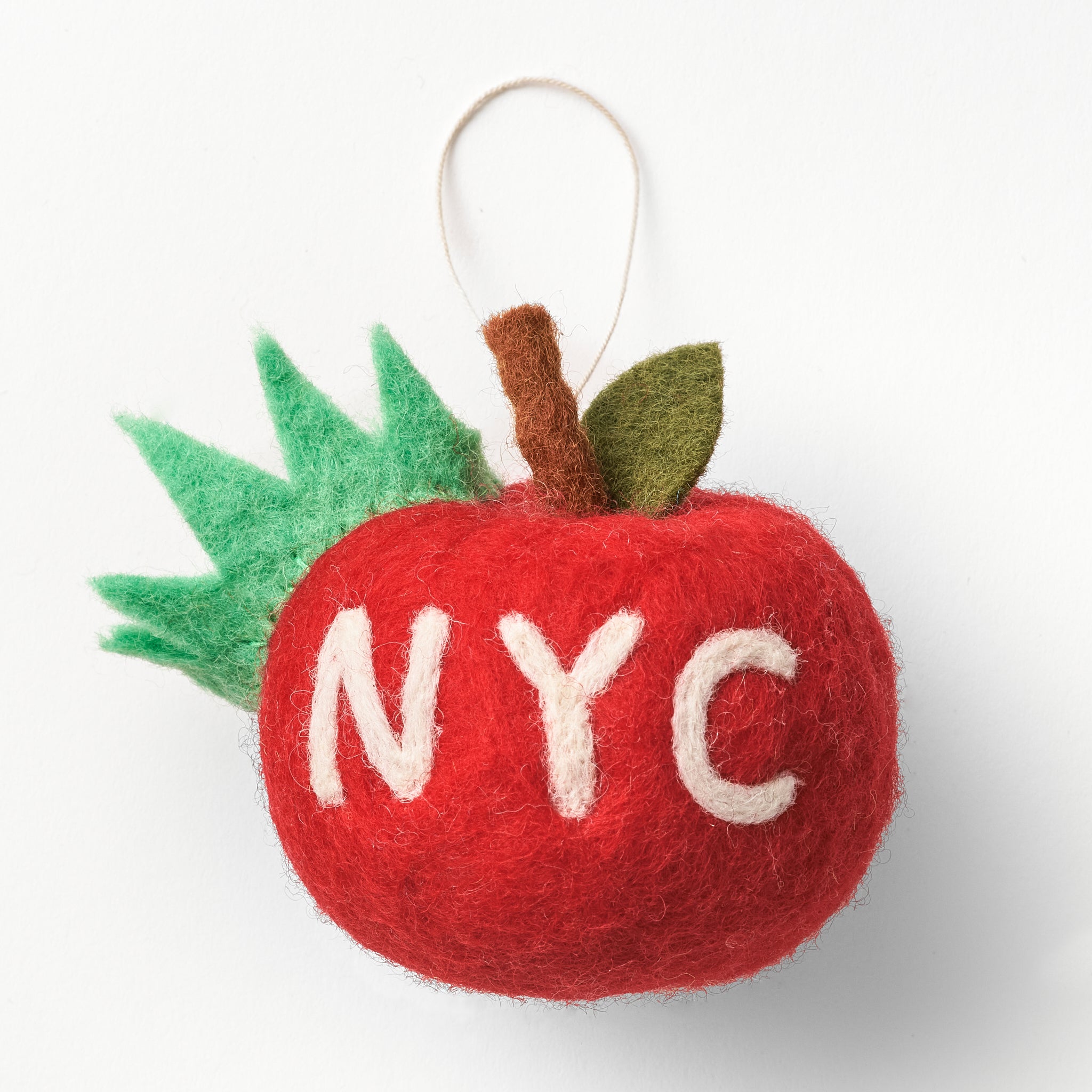Felt fair trade, handmade apple ornament with 'NYC' on a white background. 