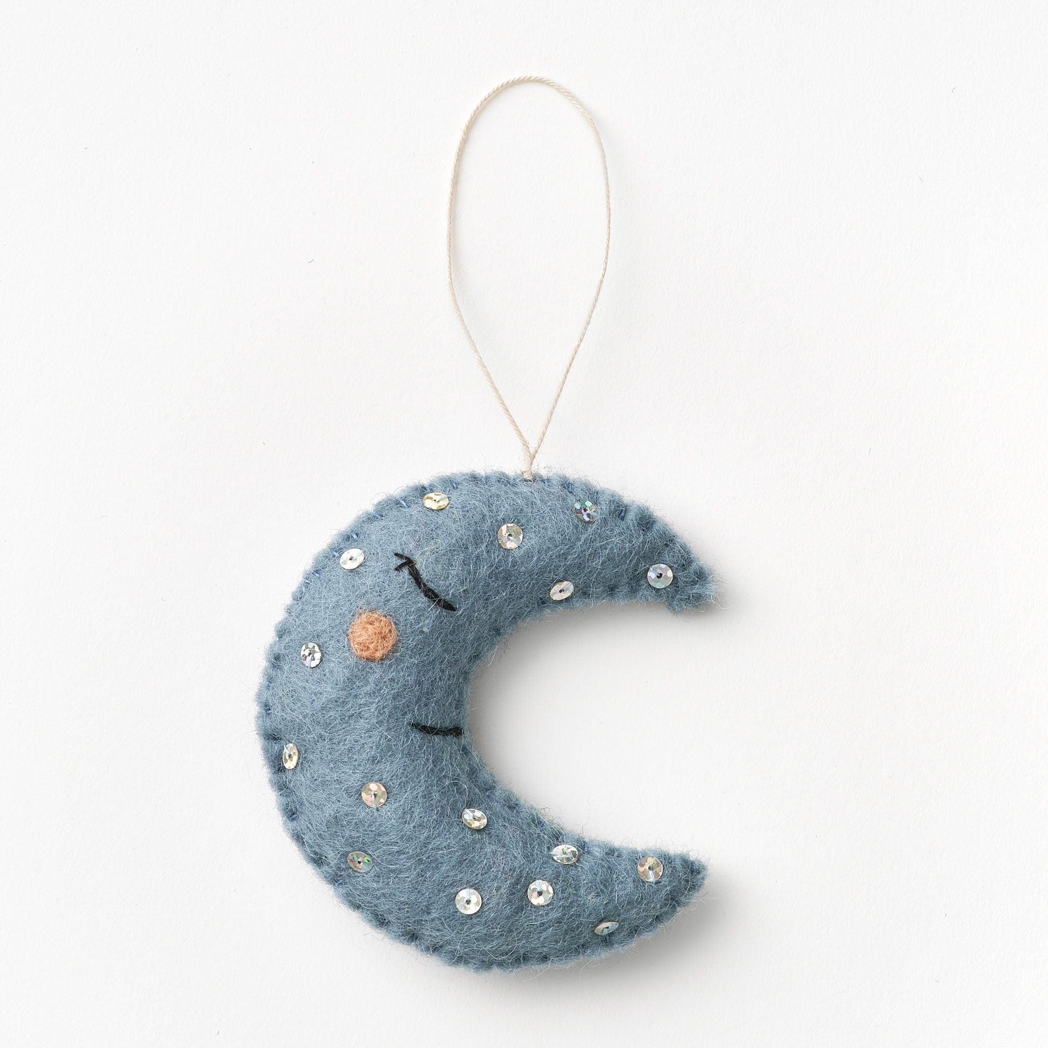 Blue crescent moon ornament with decorative elements on a white background. Felted by women artisans | Global Goods Partners