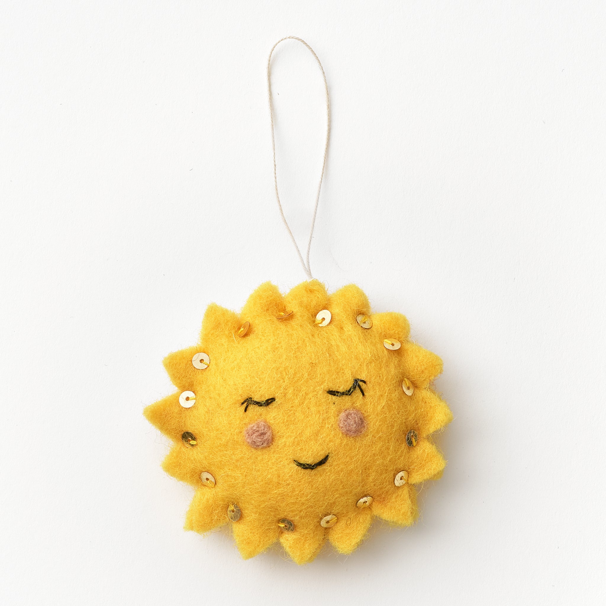 Yellow sun-shaped felt ornament with a face on a white background, handmade by women artisans in Nepal | Global Goods Partners