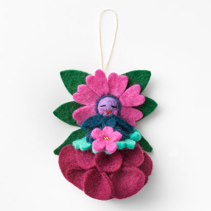 Decorative felt ornament with a face on a pink flower, hanging against a white background. Made by women artisans, fair trade | Global Goods Partners