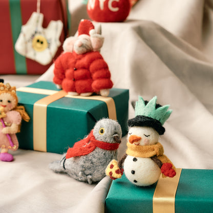 Handmade felt ornaments, including a snowman on wrapped presents with a festive background. Fair trade and made by women artisans in Nepal.