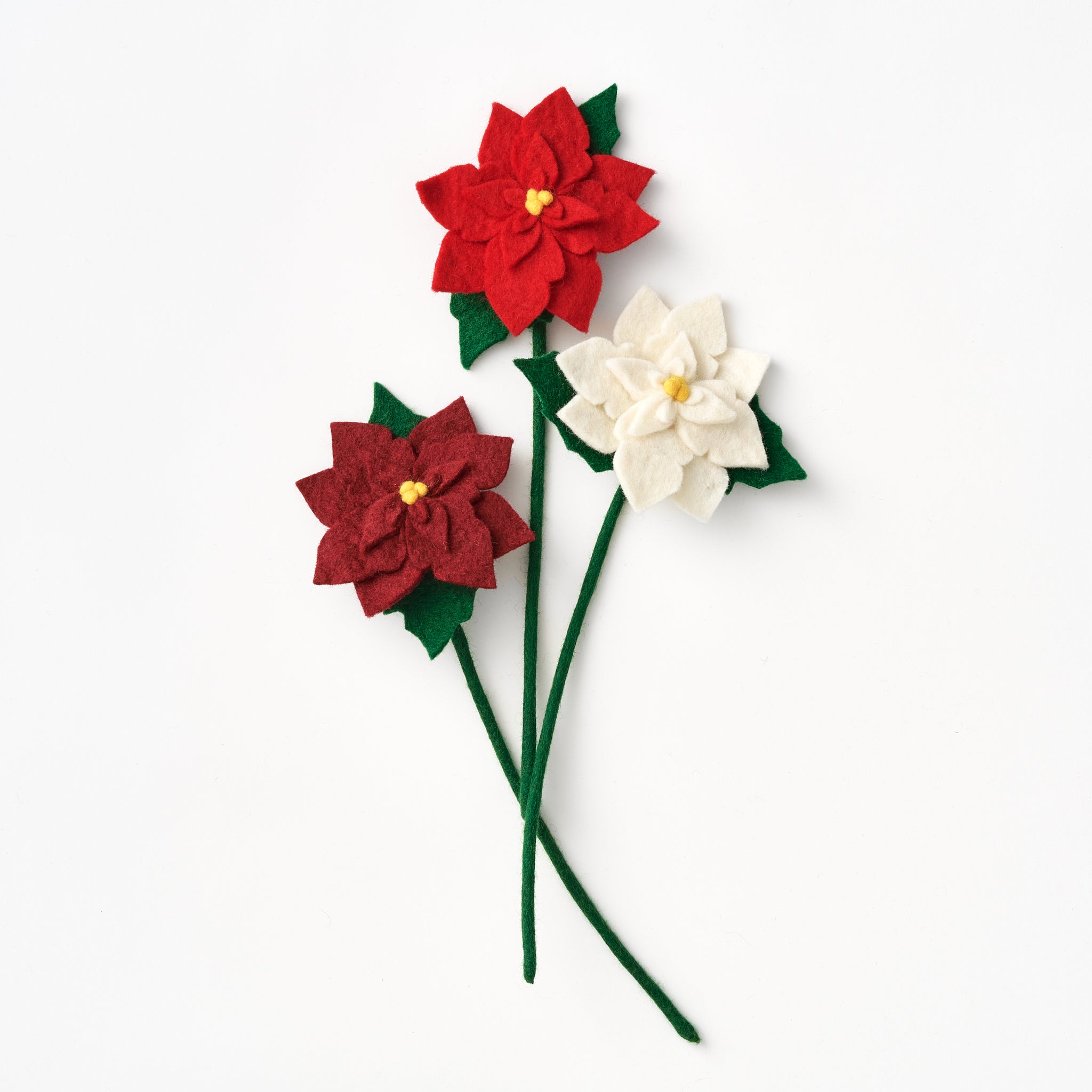 Handmade red and white poinsettia flowers on green stems against a white background, all fair trade | Global Goods Partners