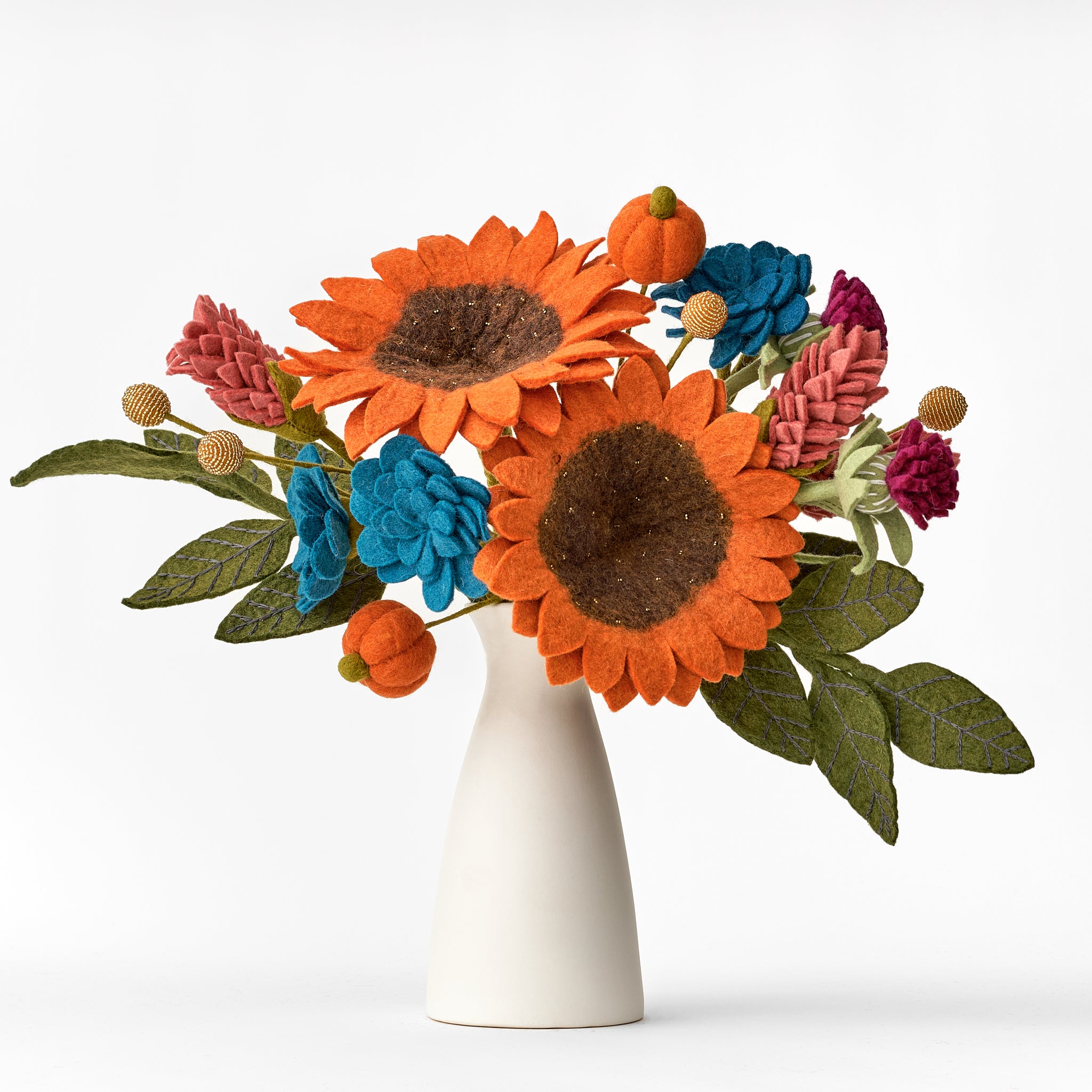 Felt flower bouquet with sunflowers and pumpkins in a white vase on a white background. Bouquet handmade by women artisans in Nepal. | Global Goods Partners