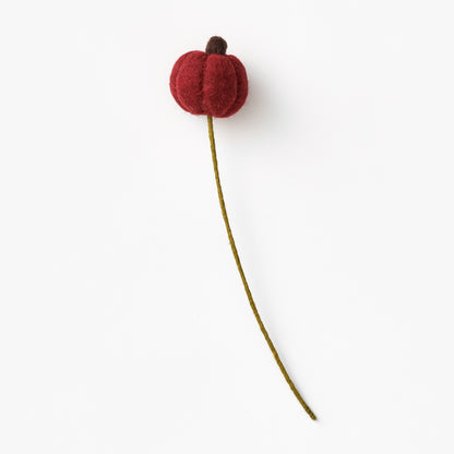 Red flower bud on a green stem against a white background, made by women artisans in Nepal | Global Goods Partners