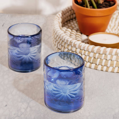 Two blue fair trade glass tumblers with floral patterns on a textured surface | Global Goods Partners