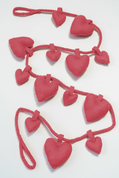Felt pink heart-shaped garland on a white background, fair trade and gives back to women artisans | Global Goods Partners