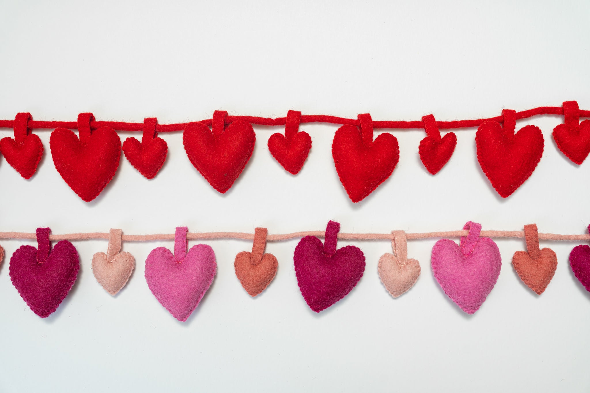 String of red and pink heart garland on a white background, handmade| Global Goods Partners