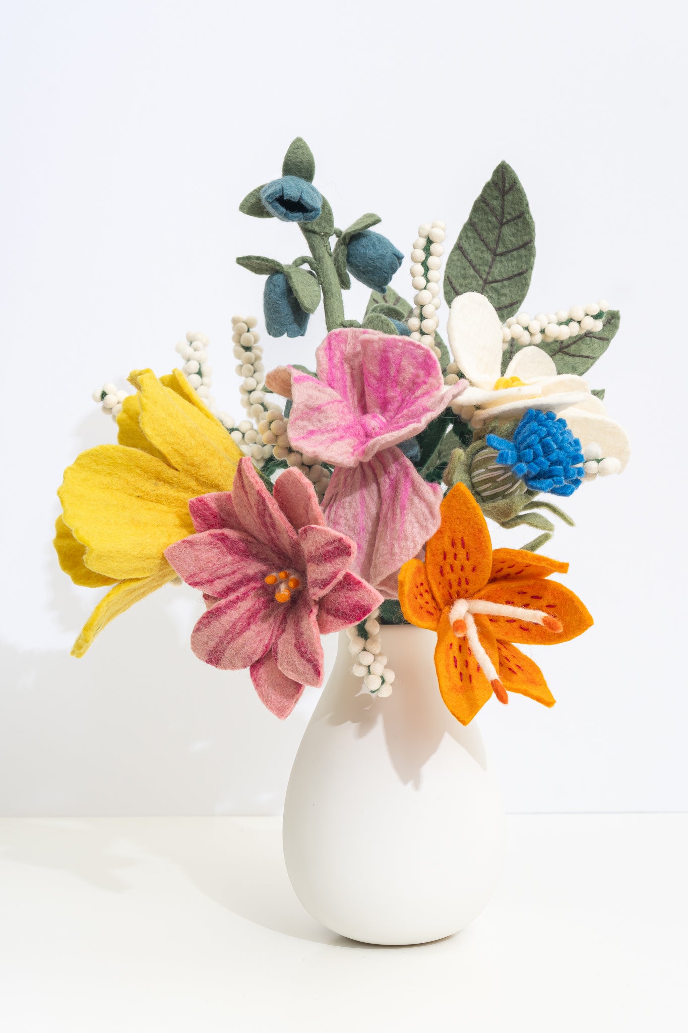 Colorful fair trade felt flower bouquet in a white vase on a light background, all handmade by women artisans | Global Goods Partners