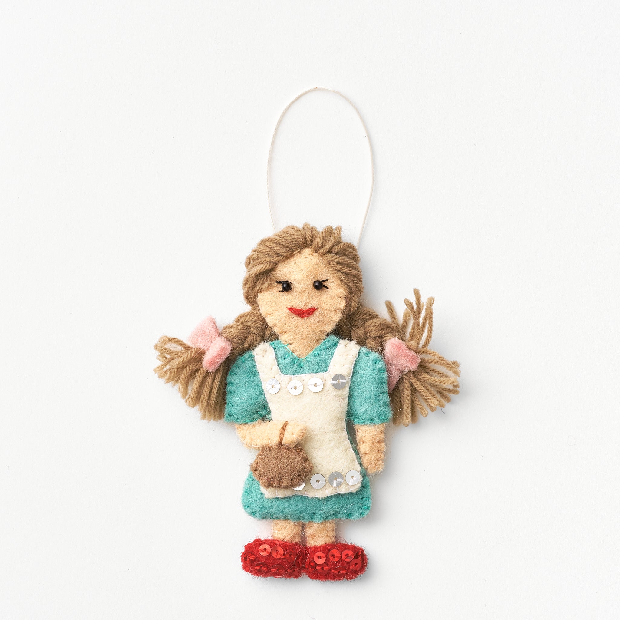 Handmade, fair trade, felt ornament of Dorothy with brown hair, wearing a blue dress and red sparky shoes, on a white background | Global Goods Partners