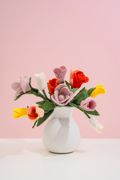 Felt flower bouquet in a white vase on a pink background made by women artisans in Nepal | Global Goods Partners
