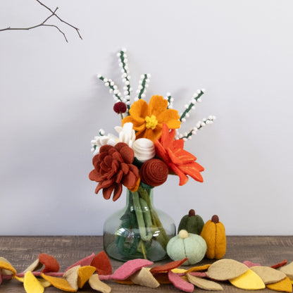 Wooden console table with decorative items including a vase of flowers, pumpkins, and autumn leaves on a plain background.