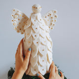 Felt angel being placed on top of a tree 